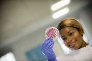Student in the lab holding an agar plate
