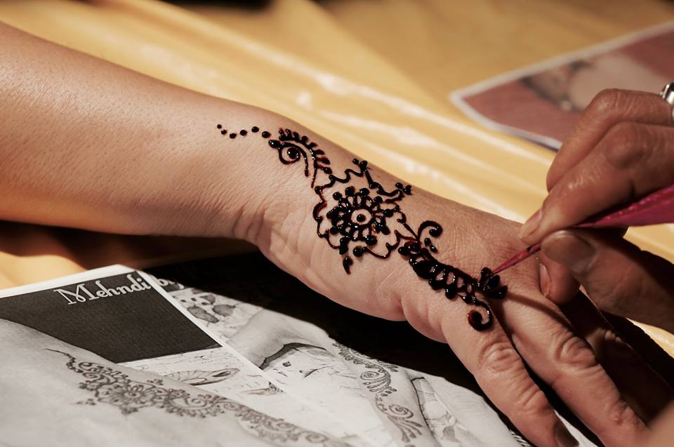 Hand being painted with henna
