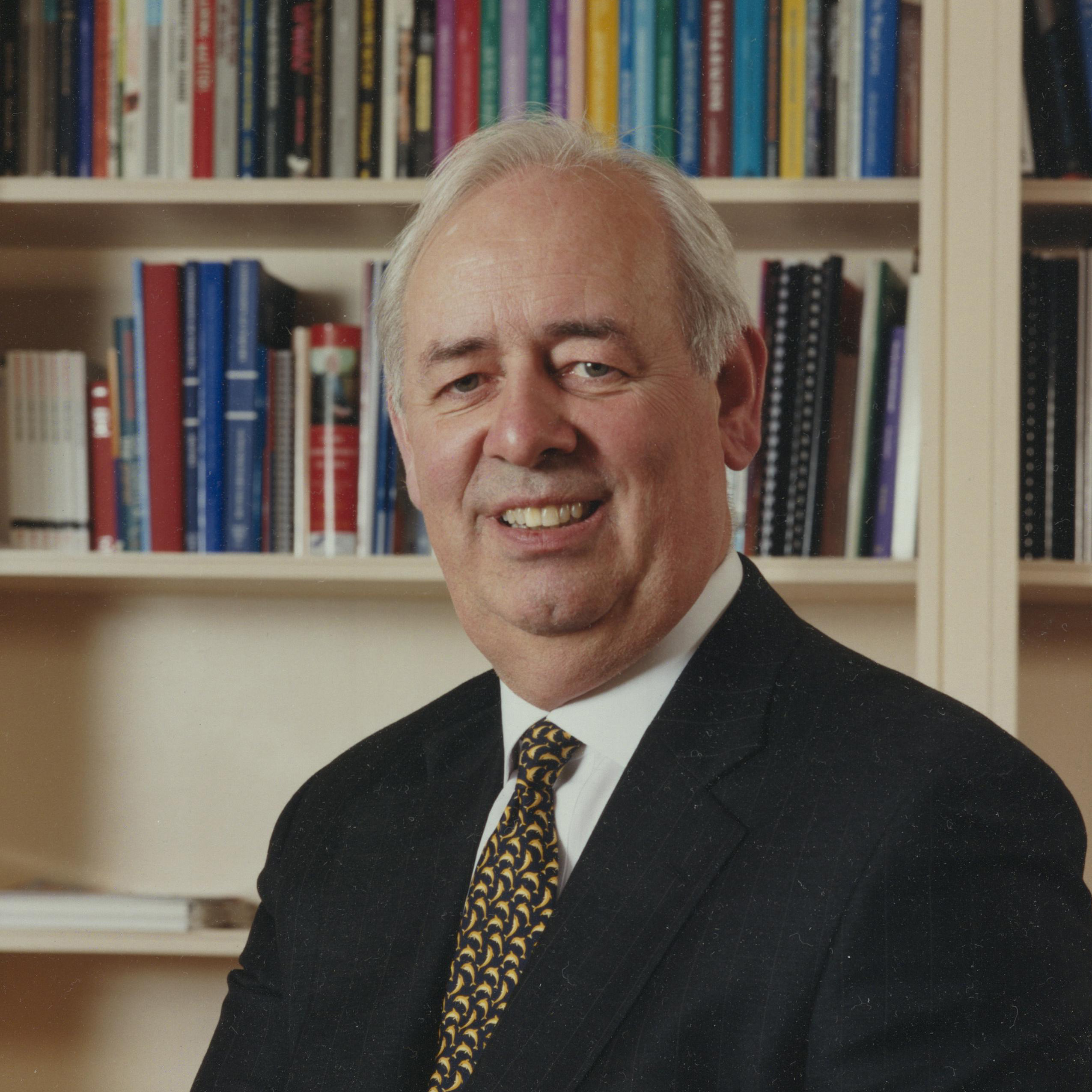 Sir Nicholas Scheele in front of a bookcase