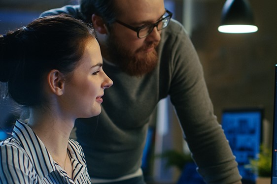 Two people are looking at a computer screen.