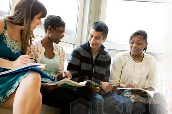 Four people are looking at textbooks and having a discussion.