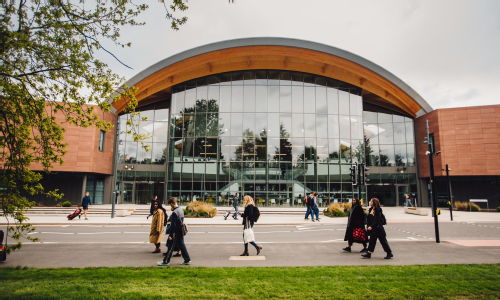 The Oculus building at the University of Warwick with students and staff walking around in front of it.