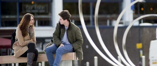 Two people sitting on a bench having a serious discussion