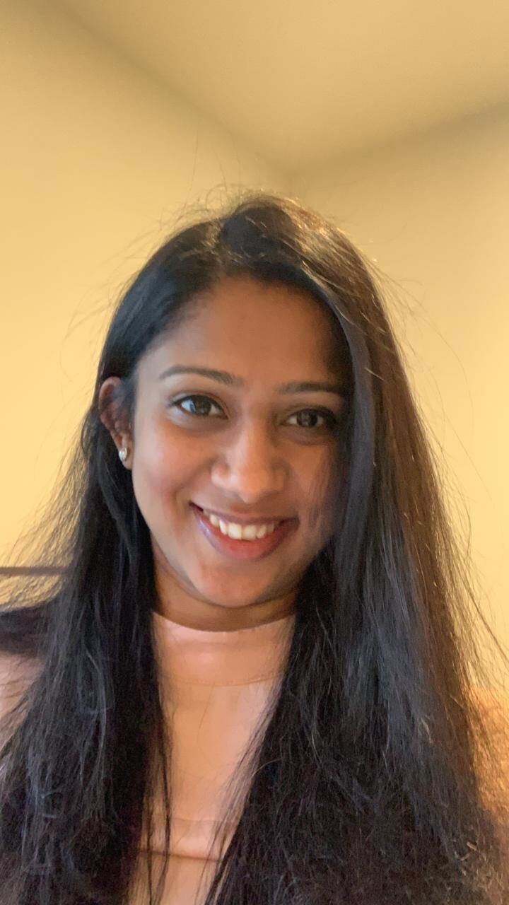 Ankita smiles at camera. She has long brown hair