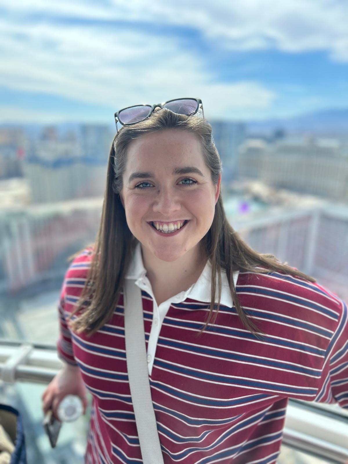 Bea wears a red and blue striped rugby shirt with sunglasses perched atop her head