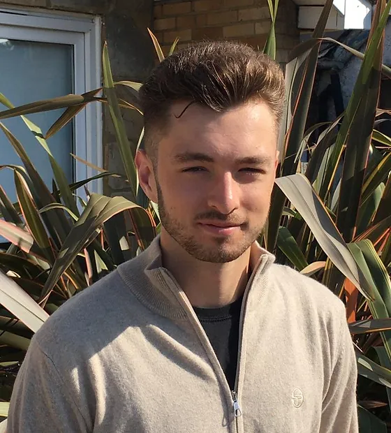 George in front of a plant