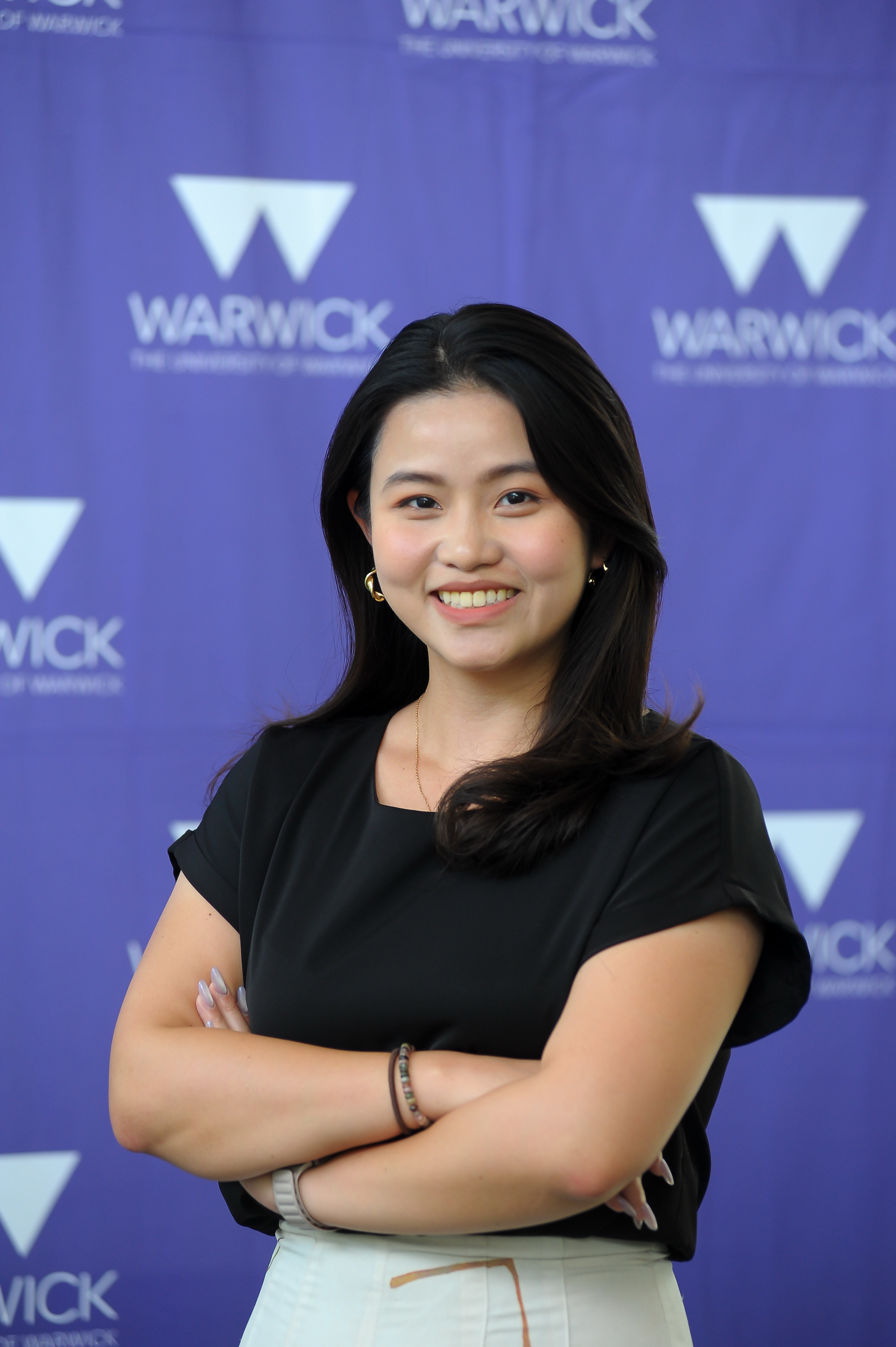 Jaclyn stands in front of a Warwick branded backdrop