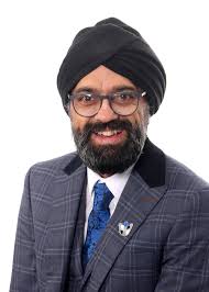 Jassa smiling at camera in a tweed suit