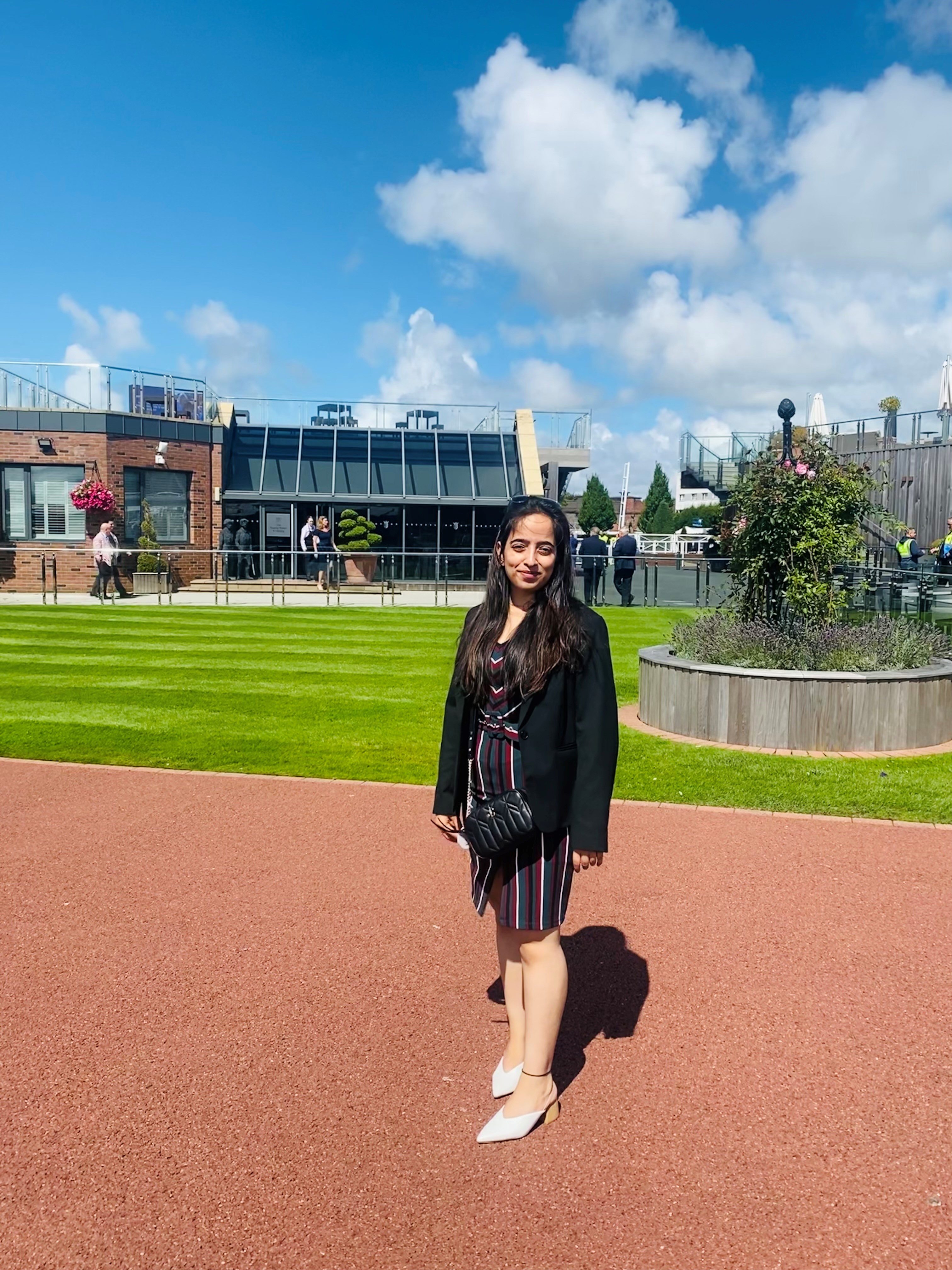 Vandana standing outdoors in formal office attire, posing confidently for a photo.