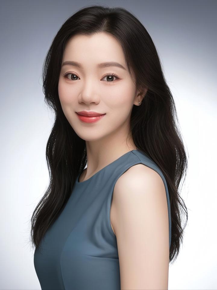 Xuling turns her head to look at camera wearing a grey-green dress