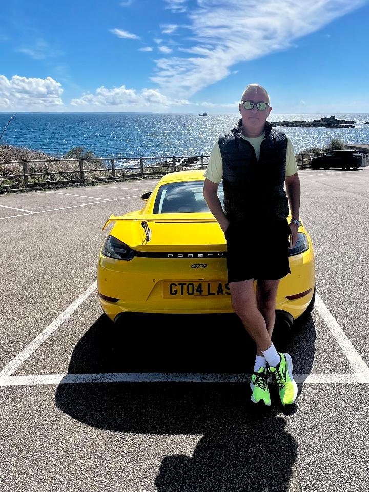 Andrew with a bright yellow Porcha at the seaside