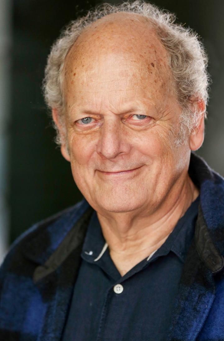 Hugh looks to camera with a smile