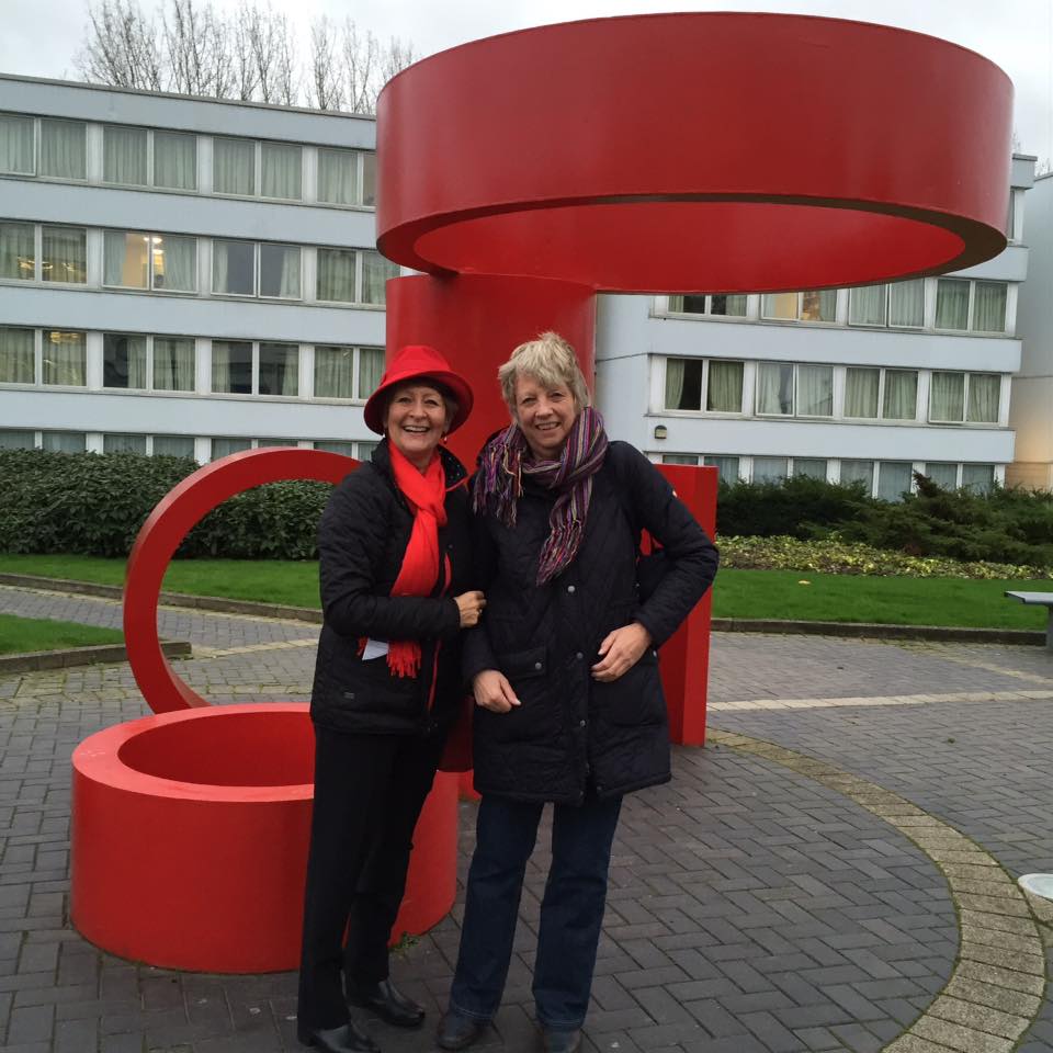 Izabela and a friend stand next to the art sculpture in the Red Square on Warwick's campus