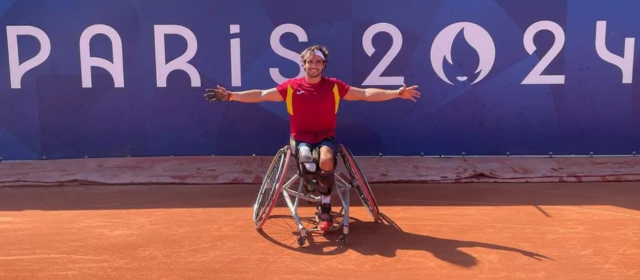 Dani holds out his hands in front of a sign reading PARIS 2024