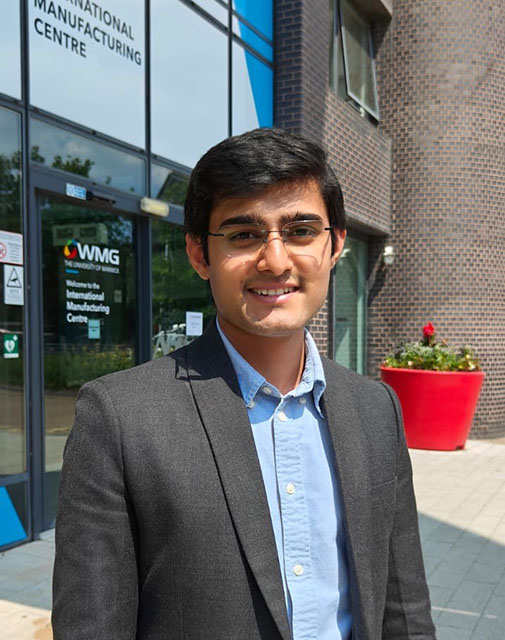 ozair standing outside imc building on campus head and shoulders shot looking happy