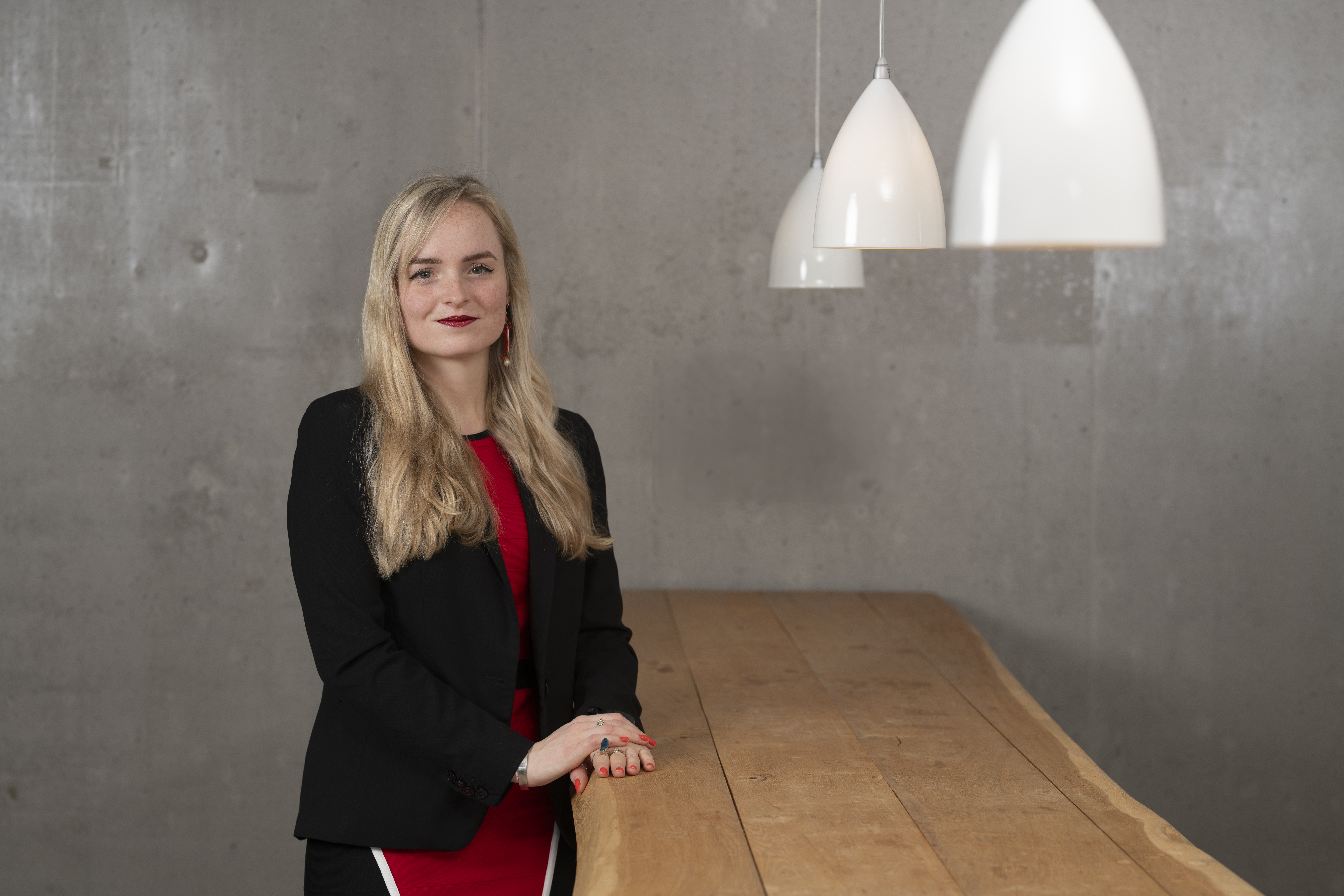 Laura in a red suit and black blazer