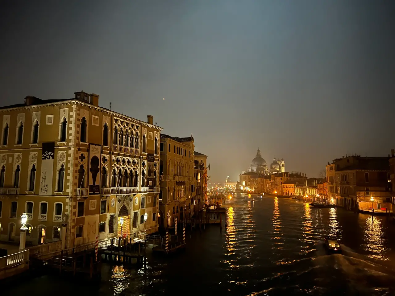 A view of Venice at night with lights reflecting in the water