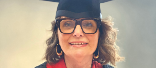 Allison in her graduation robes with a red hood