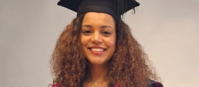 Cat in her graduation robes with a red hood