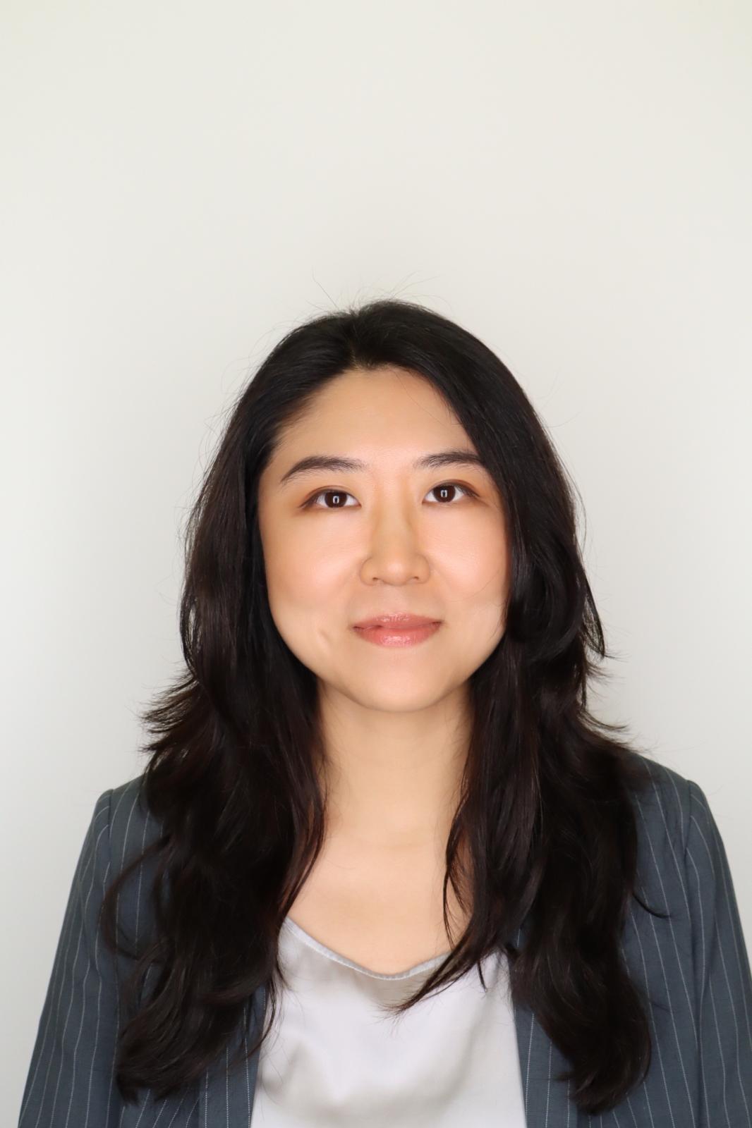 Constance stands before a white wall 