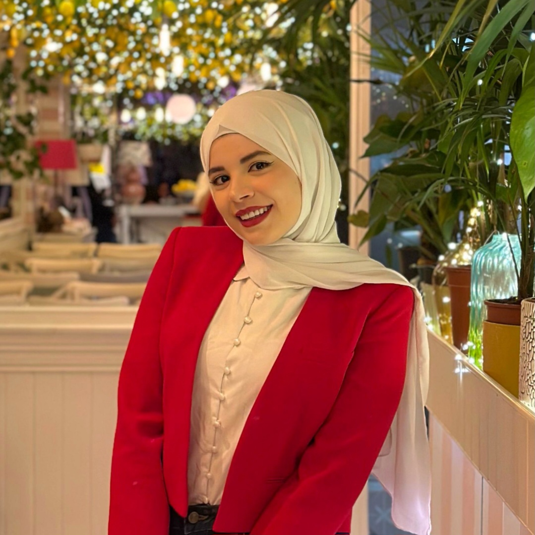 Duaa wears a red blazer and a cream hijab