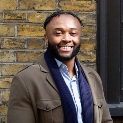 Patrick outside in a blue scarf and brown jacket