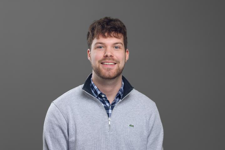 Timothy against a grey background with a grey jumper