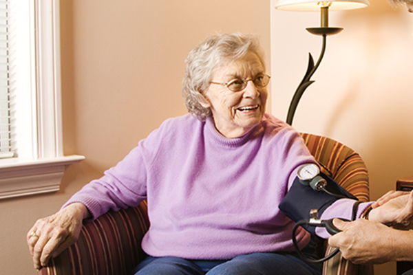 Elderly lady having blood pressure check at home