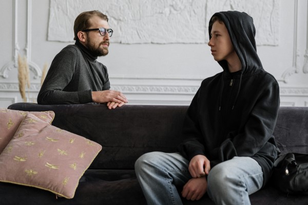 An Adolescent boy talking to an adult