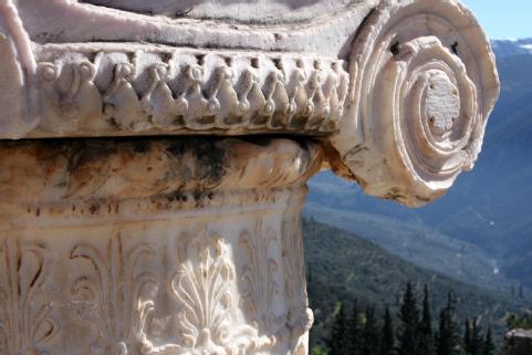 Close-up image of the capital of a decorated Ionic column at the archeological site of Delphi.