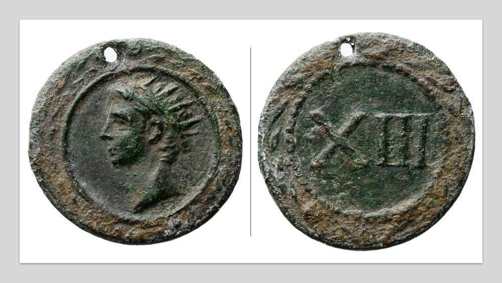 A token showing a portrait of the deified Augustus and the number XIII that is pierced