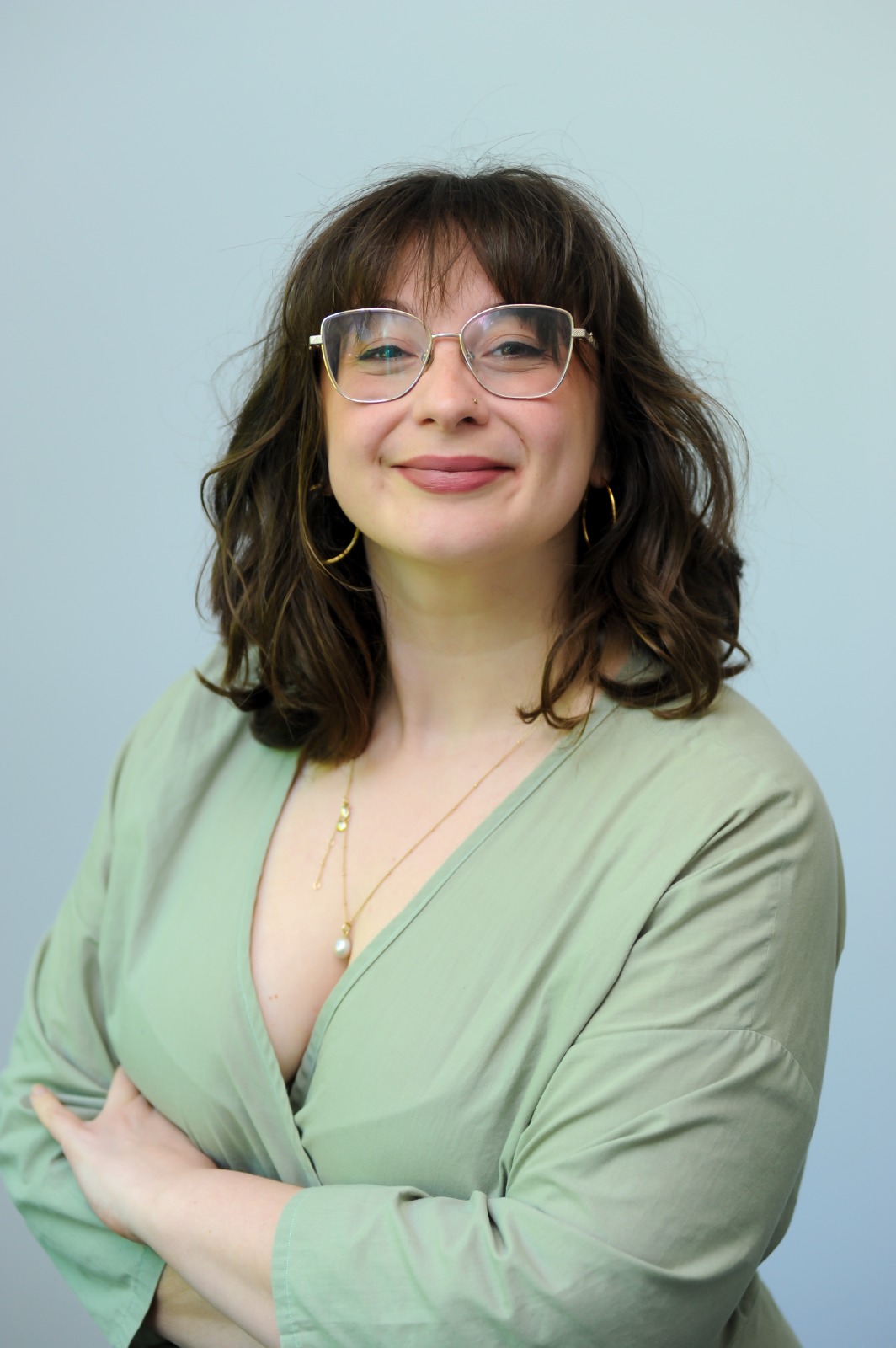 Roxanne wearing a green jumpsuit and smiling
