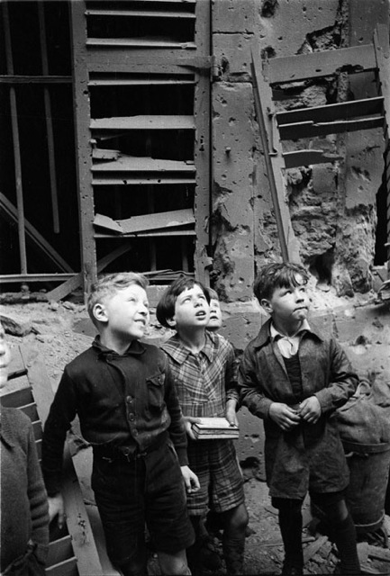 Children looking up in war damaged surroundings. Caen, c.1944