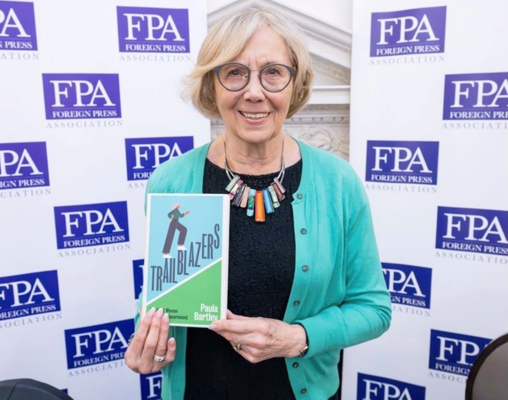 Dr Paula Bartley holding her latest book Trailblazers