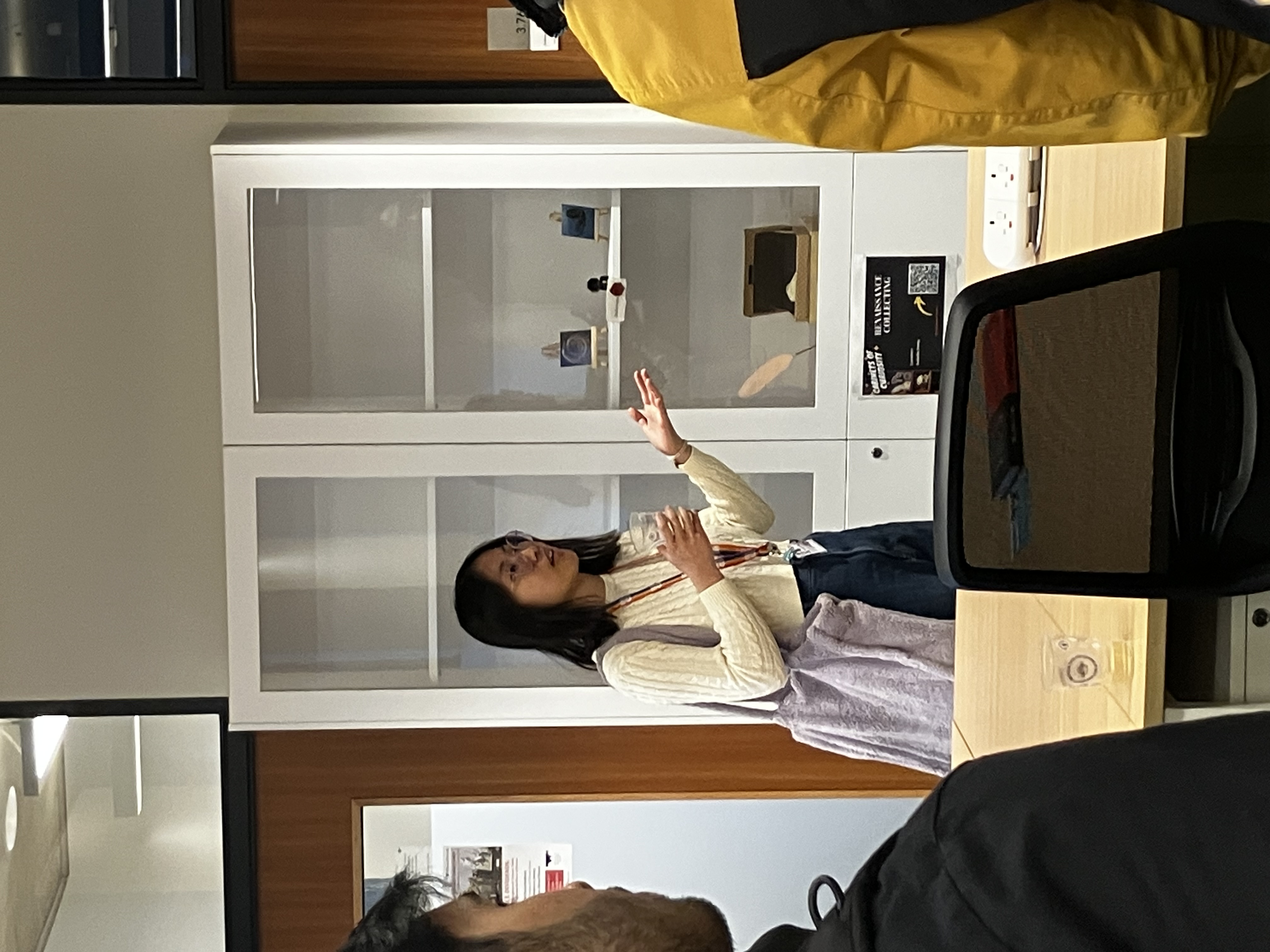 Student talking by a cabinet