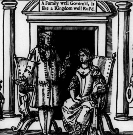 Man and women on chairs, man standing up giving order