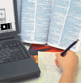 Text being translated with laptop computer and notepad and pen