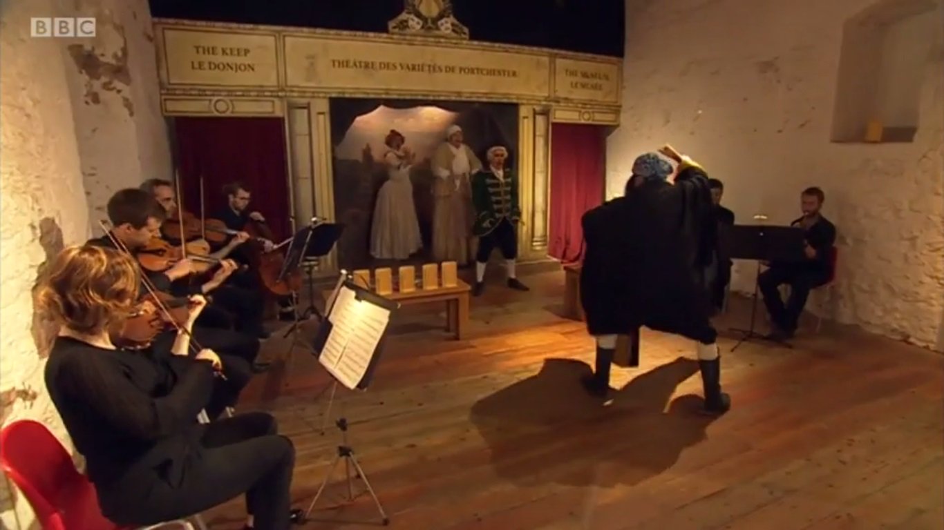 actors and orchestra rehearsing in the keep at Portchester