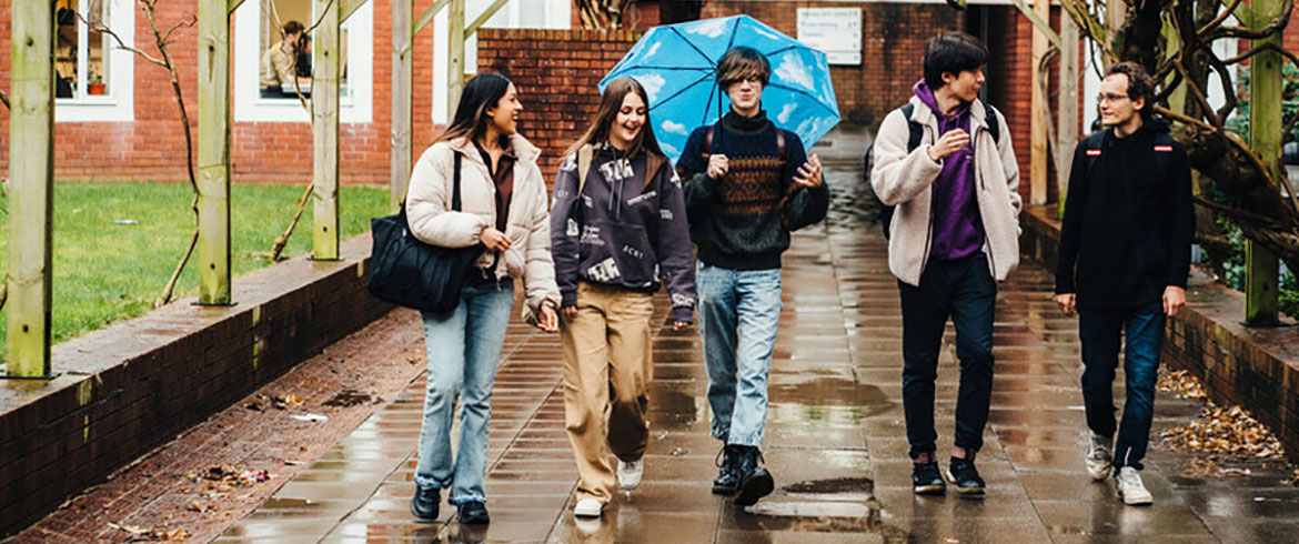 Students walking outside in the rain