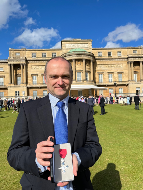 An image of Professor Lockley at the garden party holding his MBE