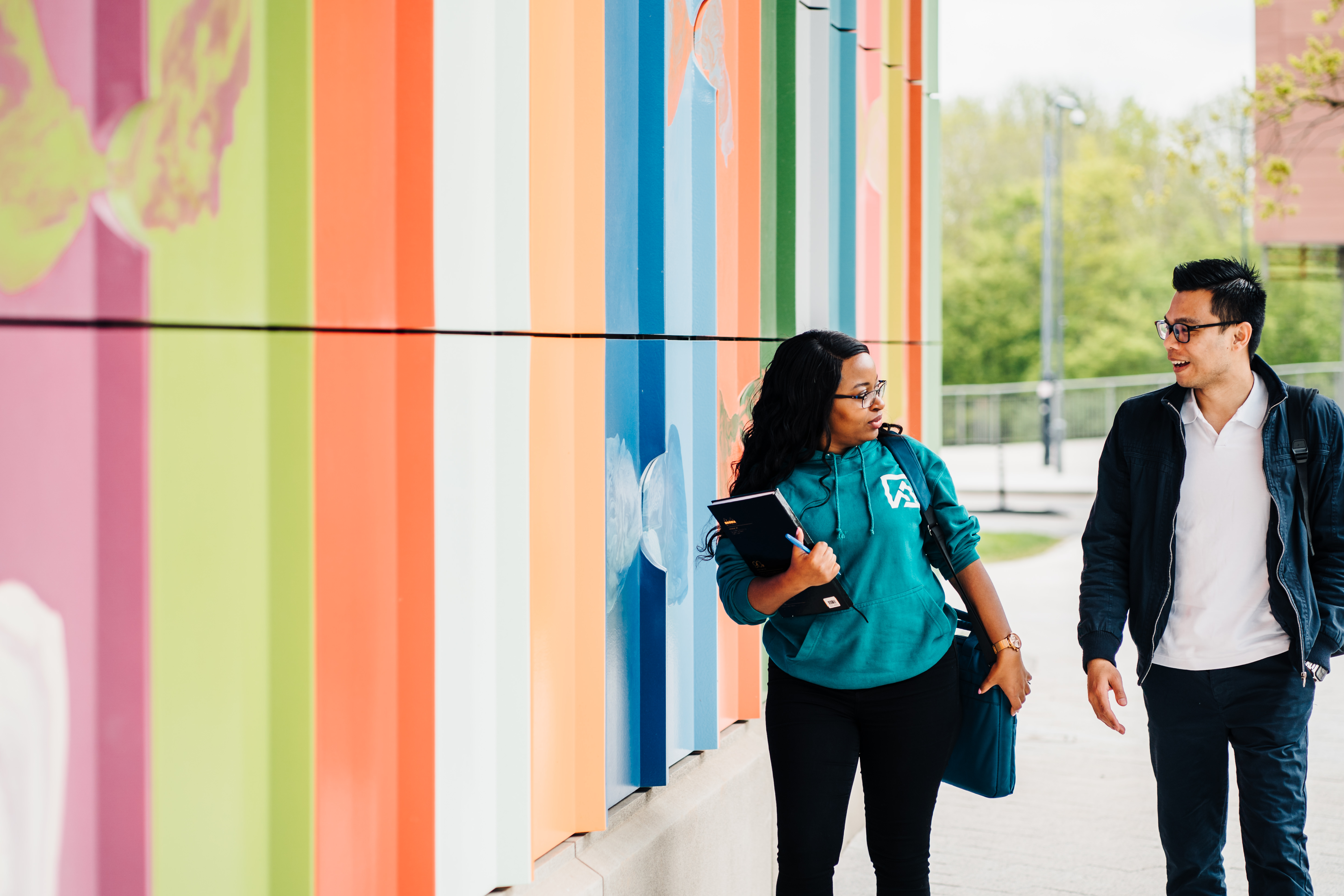 Two students walking outside of the Faculty of Arts Building