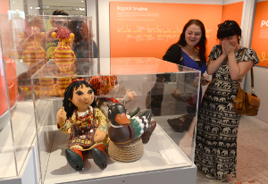 Woman looking at Rosie and Jim dolls