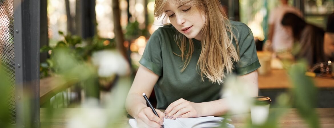 Female student reading her notes in a cafe