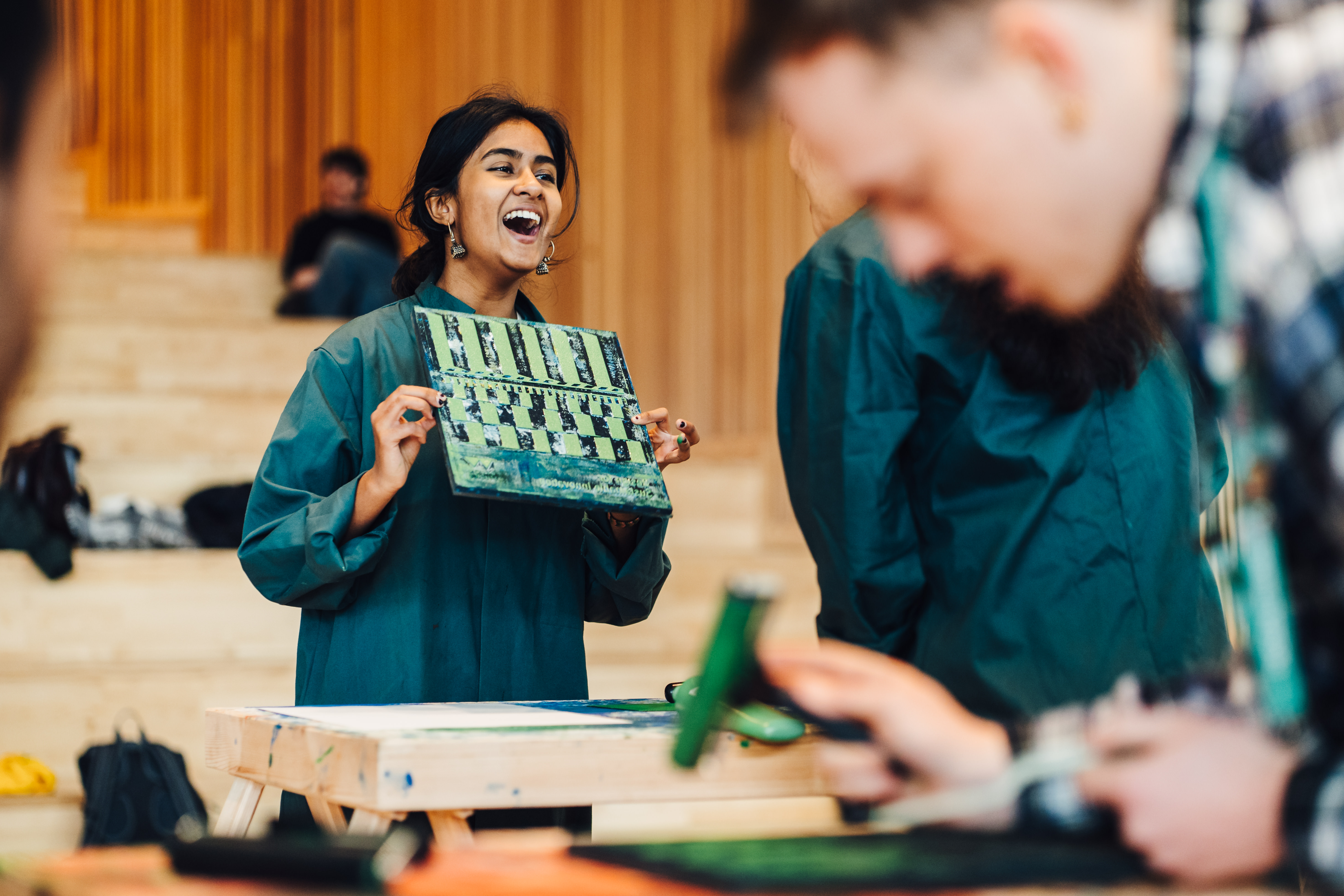 Student laughing as they complete a block printing activity in mobile design studio