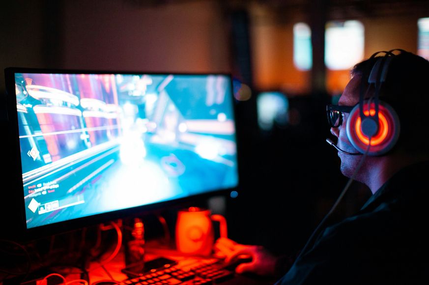 Man in headphones looks at computer screen