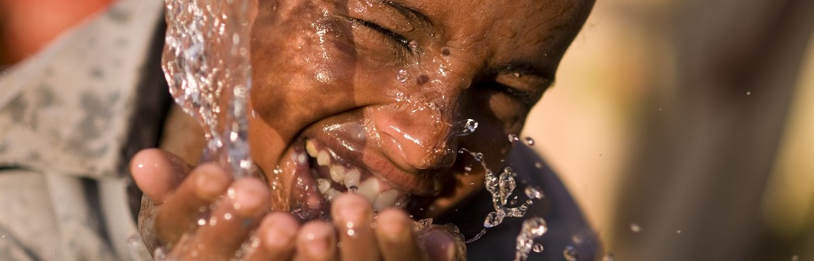 Child smiling whilst drinking water