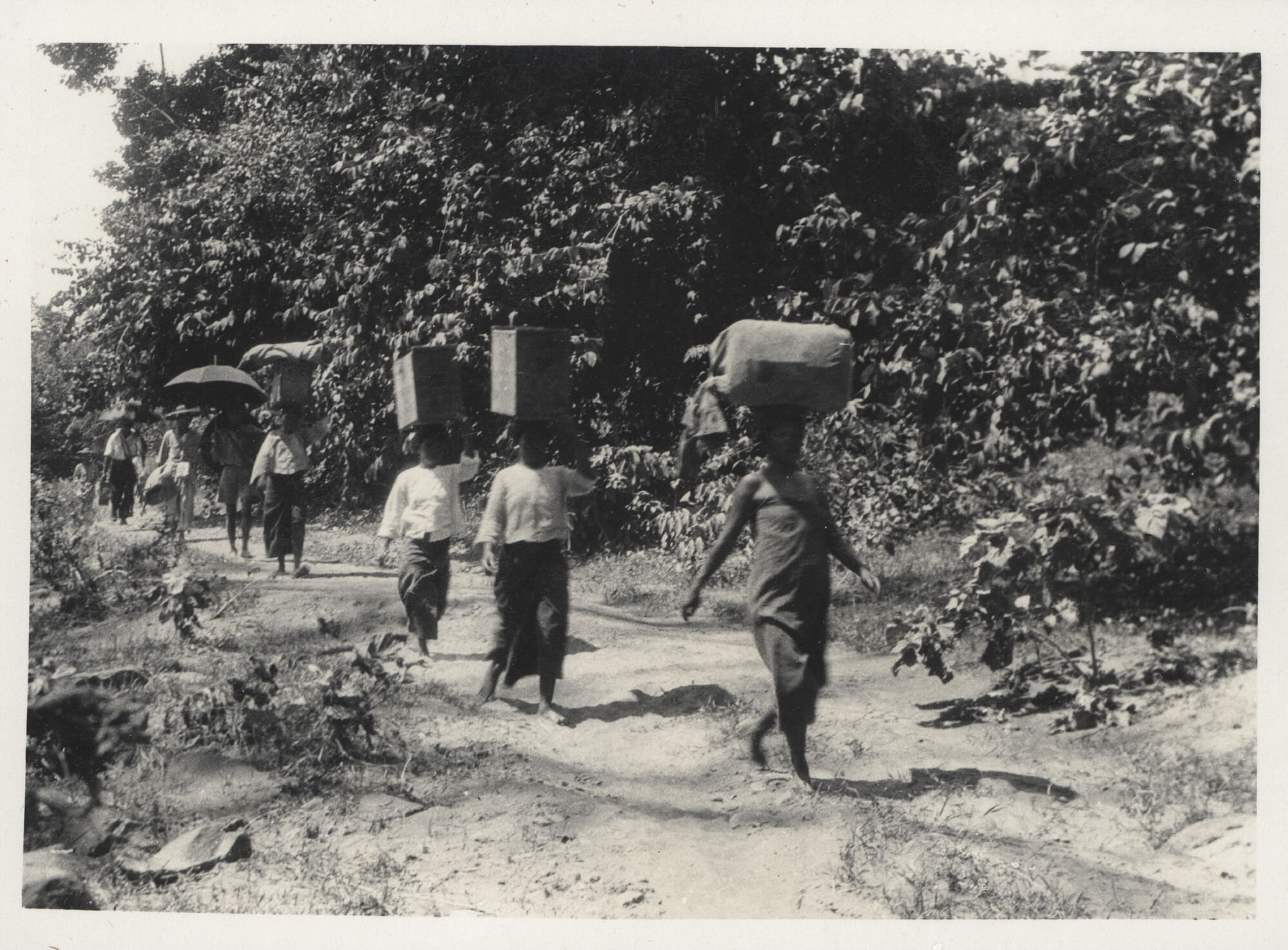 Local women transport military kit used by the British colonial Indian Army as they were undertaking a frontier exploratory expedition in Burma (Myanmar), 1920s.