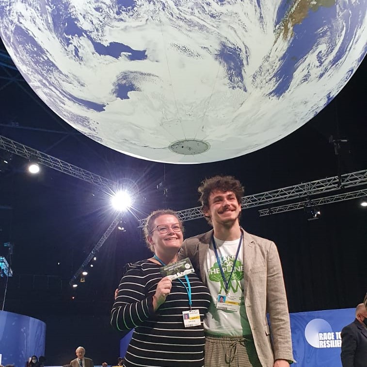 Dr Jess Savage and Simon at COP26 with a bar of The Change Chocolate