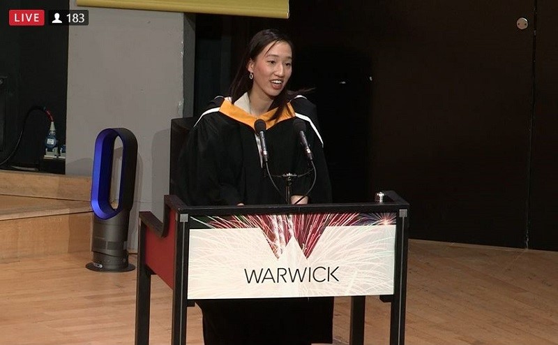 Elaine stood at a podium at the Summer Graduation Ceremony, speaking to the Class of 2022