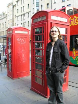 Dr Romain Chenet as a student standing in front of a red British phonebox